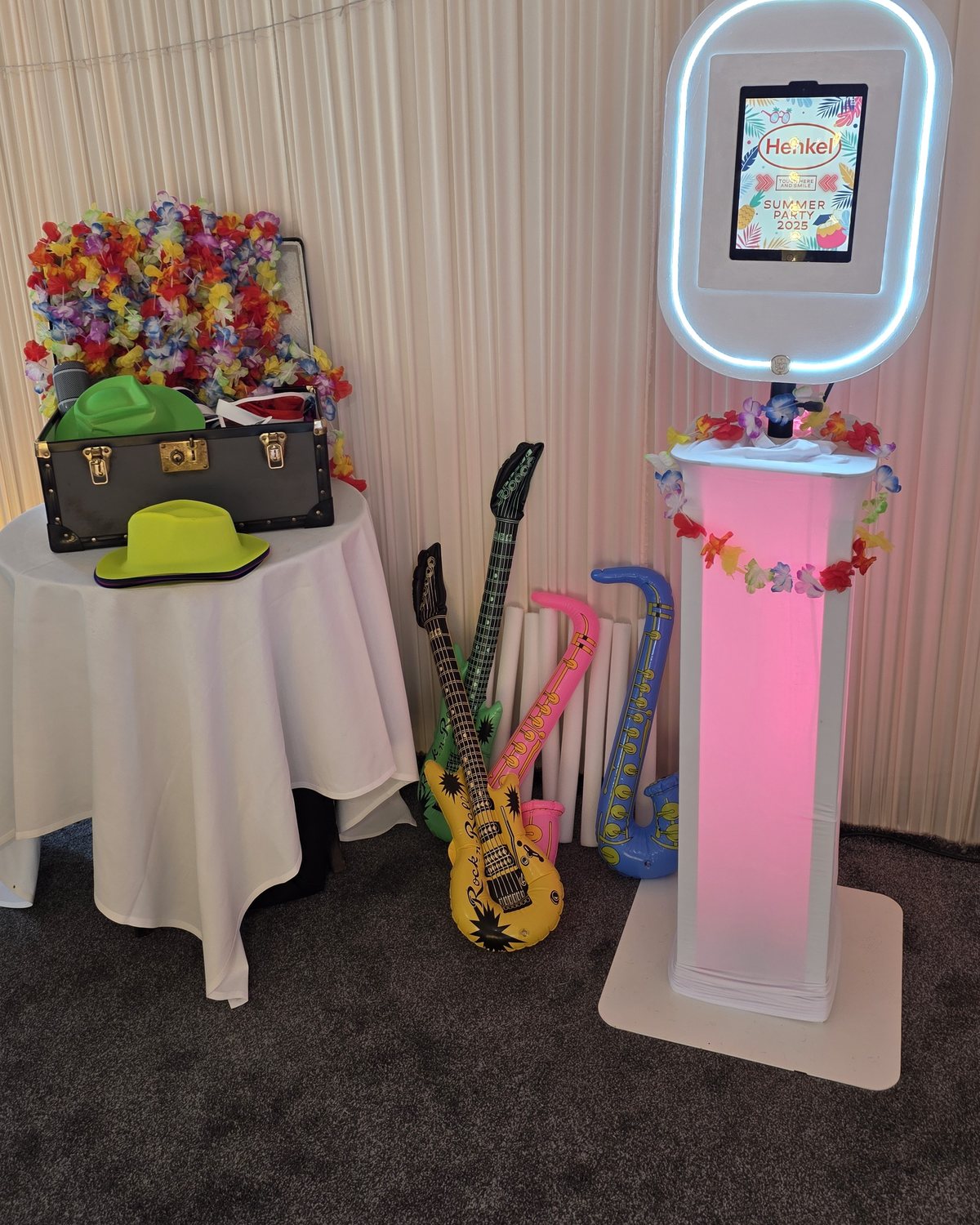 The selfie photo pod with its ring light on, beside a table of props