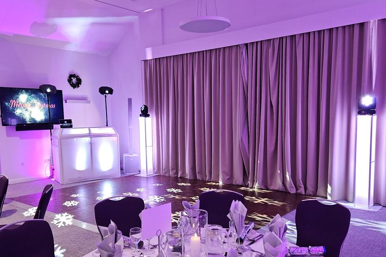 A Christmas party set-up at Aubrey Park, with snowflake gobos on the dance floor and a laid table in the foreground