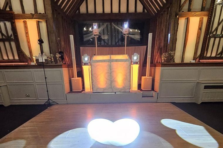 DJ booth and dance floor in the barn at Essendon Country Club, with heart gobos projected onto the wooden floor