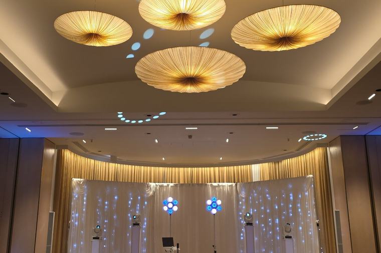 The ballroom at The Grove, with its gold pendant ceiling and a lit starlight backdrop behind the DJ booth